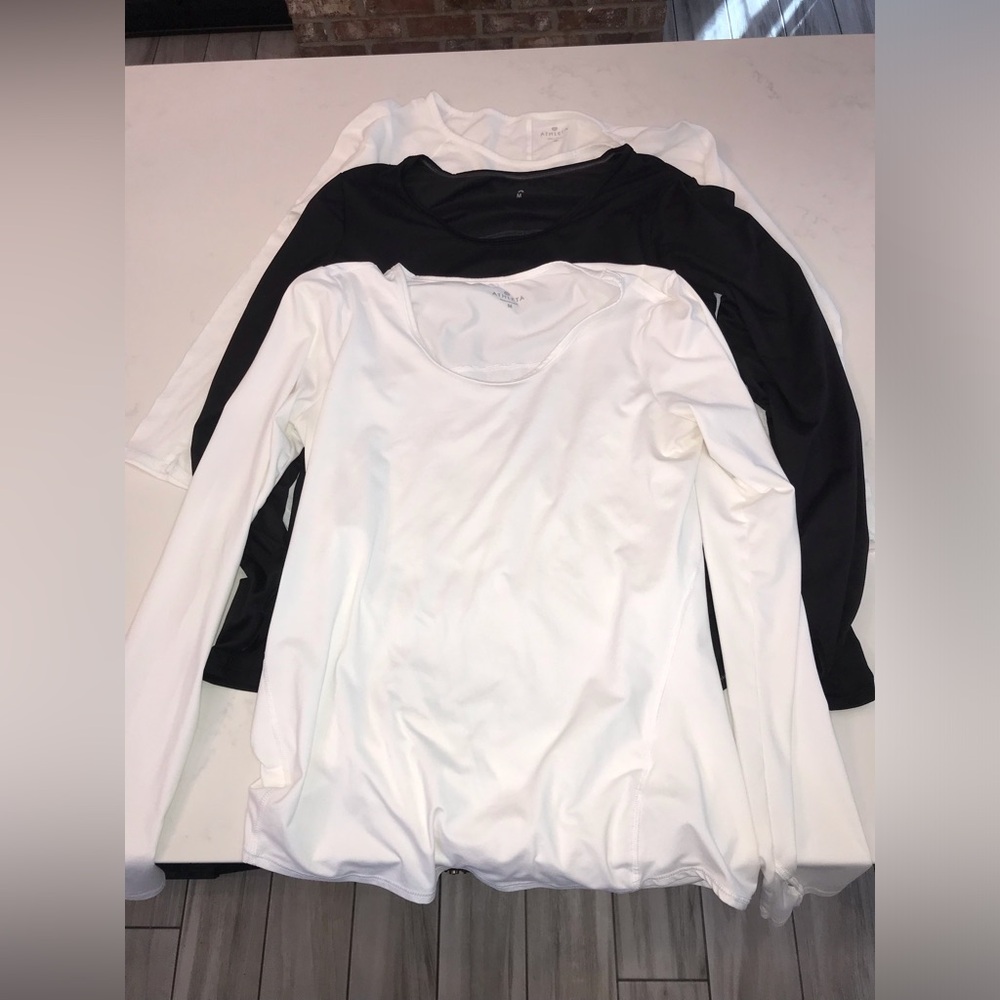 Three size medium Athleta shirts, two white and one black sold as a bundle